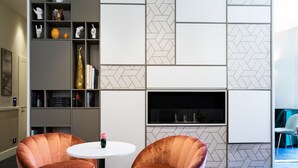 Una sala de estar moderna con dos sillones de terciopelo, una mesa blanca y una chimenea.