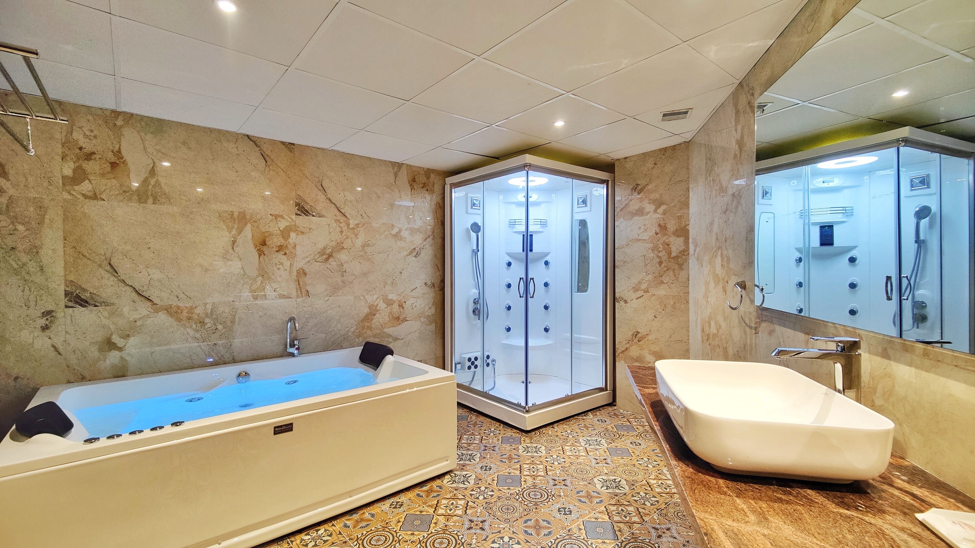 Un baño moderno con una bañera independiente, ducha a ras de suelo y un espejo grande.