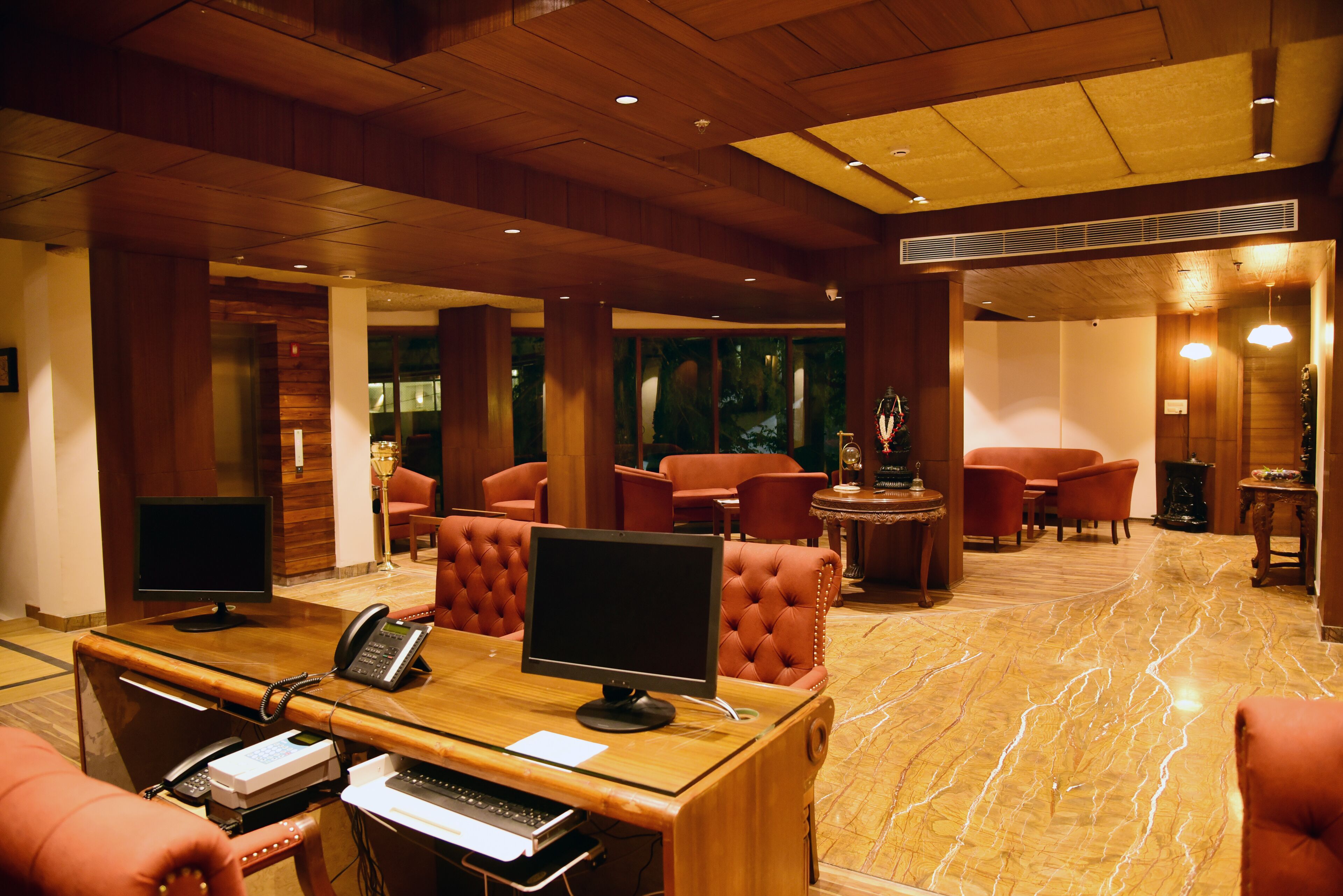 A lobby with a reception desk, multiple seating areas, and a large window.