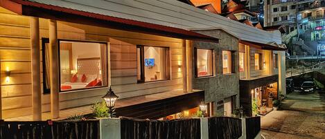 A modern hotel with multiple bedrooms, each with a large window and a view of the street.
