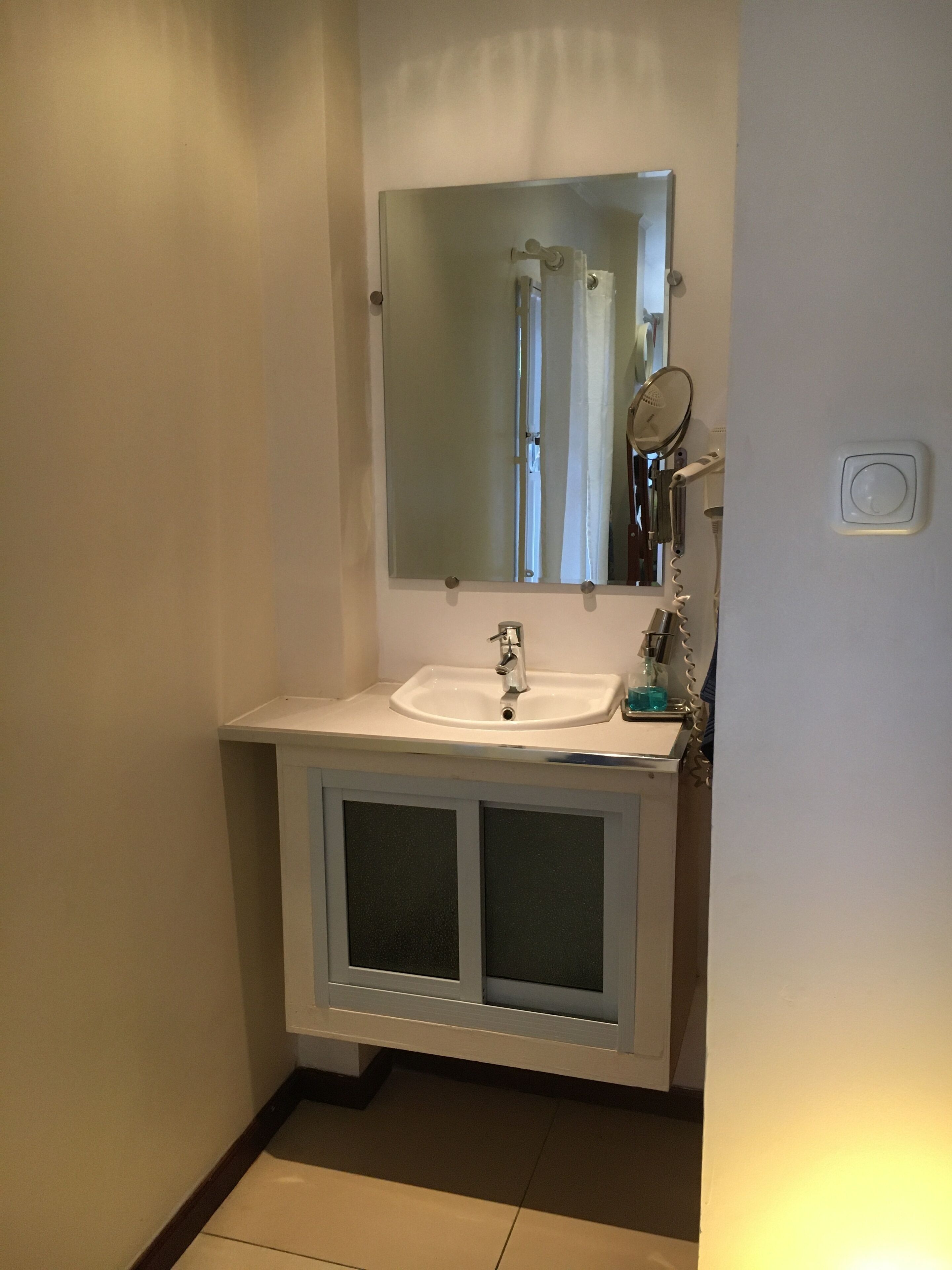A bathroom with a white sink, a mirror, and a shower curtain.