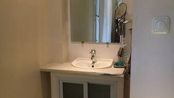 A bathroom with a white sink, a mirror, and a shower curtain.