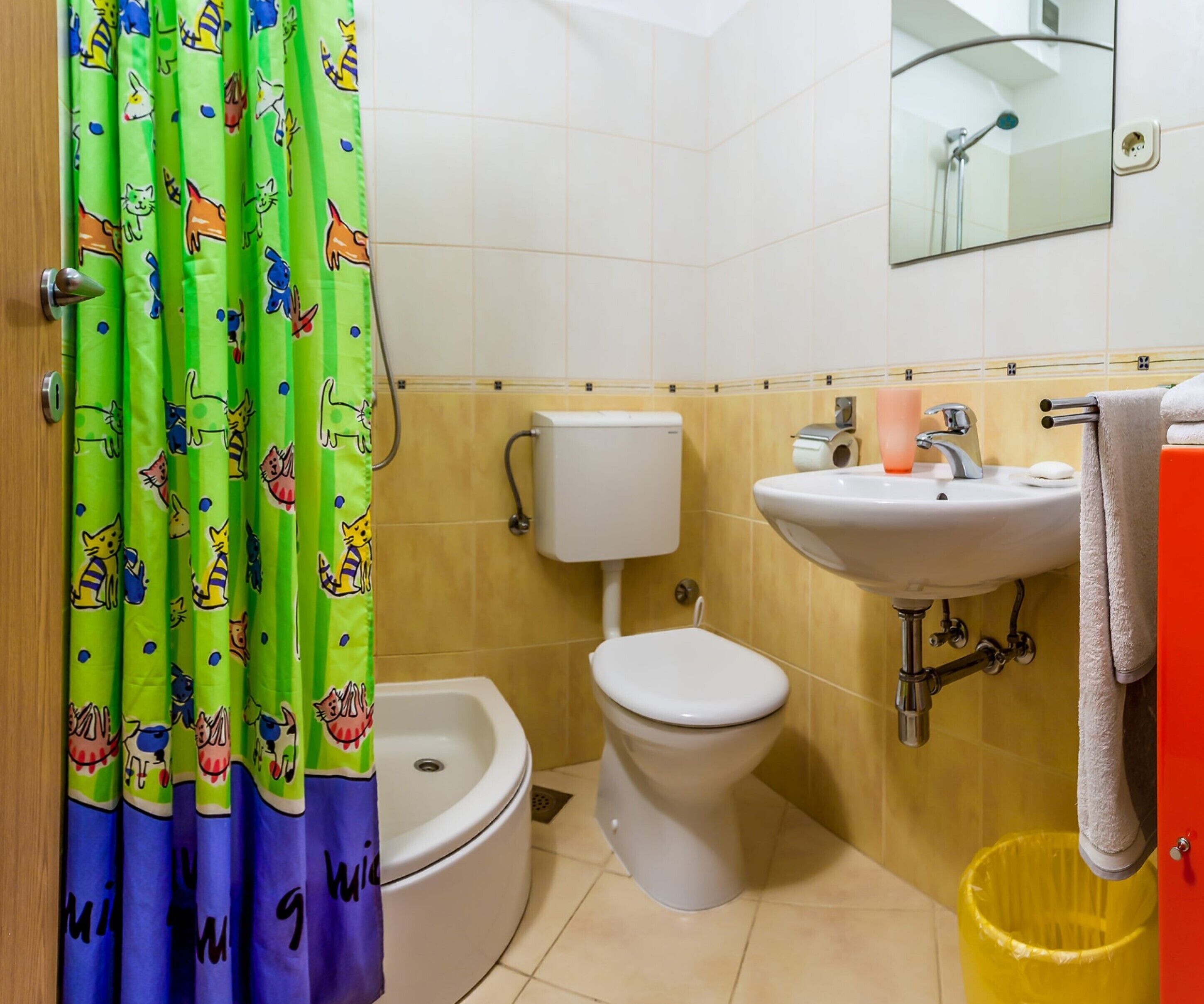 A bathroom with a toilet, bidet, sink, and a mirror.