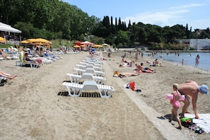 Relax on the beach with comfortable sun loungers and shaded areas.
