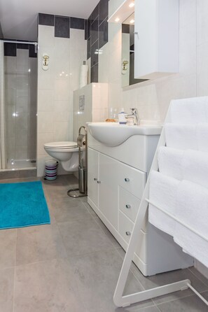 A modern bathroom with a shower, toilet, and sink. - Apartments Dalmacija (Omis)