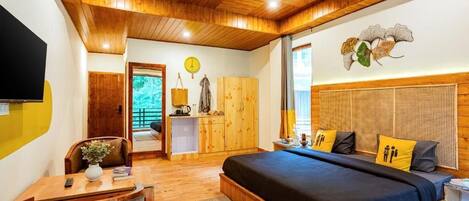 Une chambre avec un plafond en bois, un lit recouvert d’une couvre-lit bleu foncé et une tête de lit en bois.
