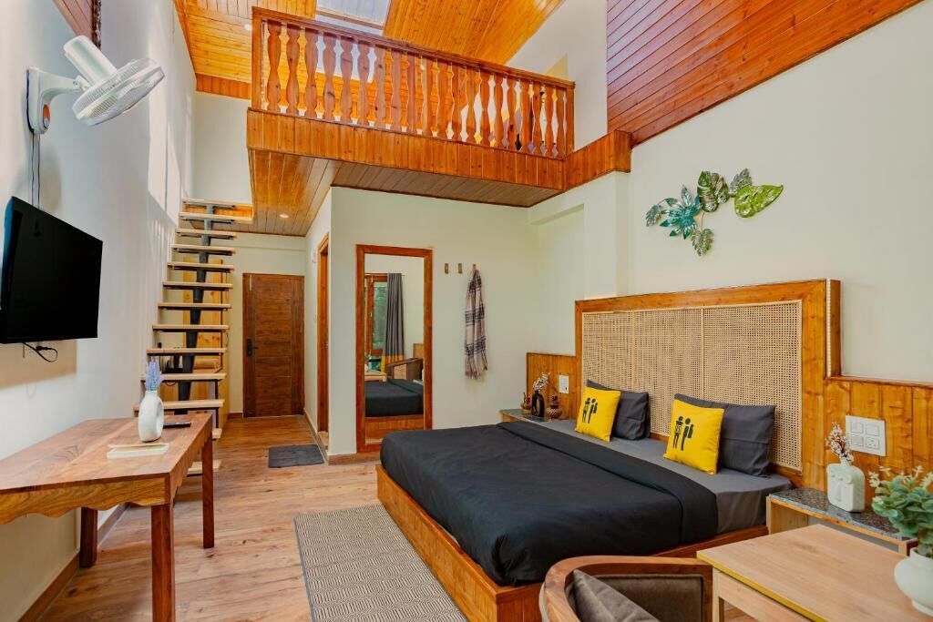 A bedroom with a large bed, wooden headboard, and a balcony with a wooden railing.