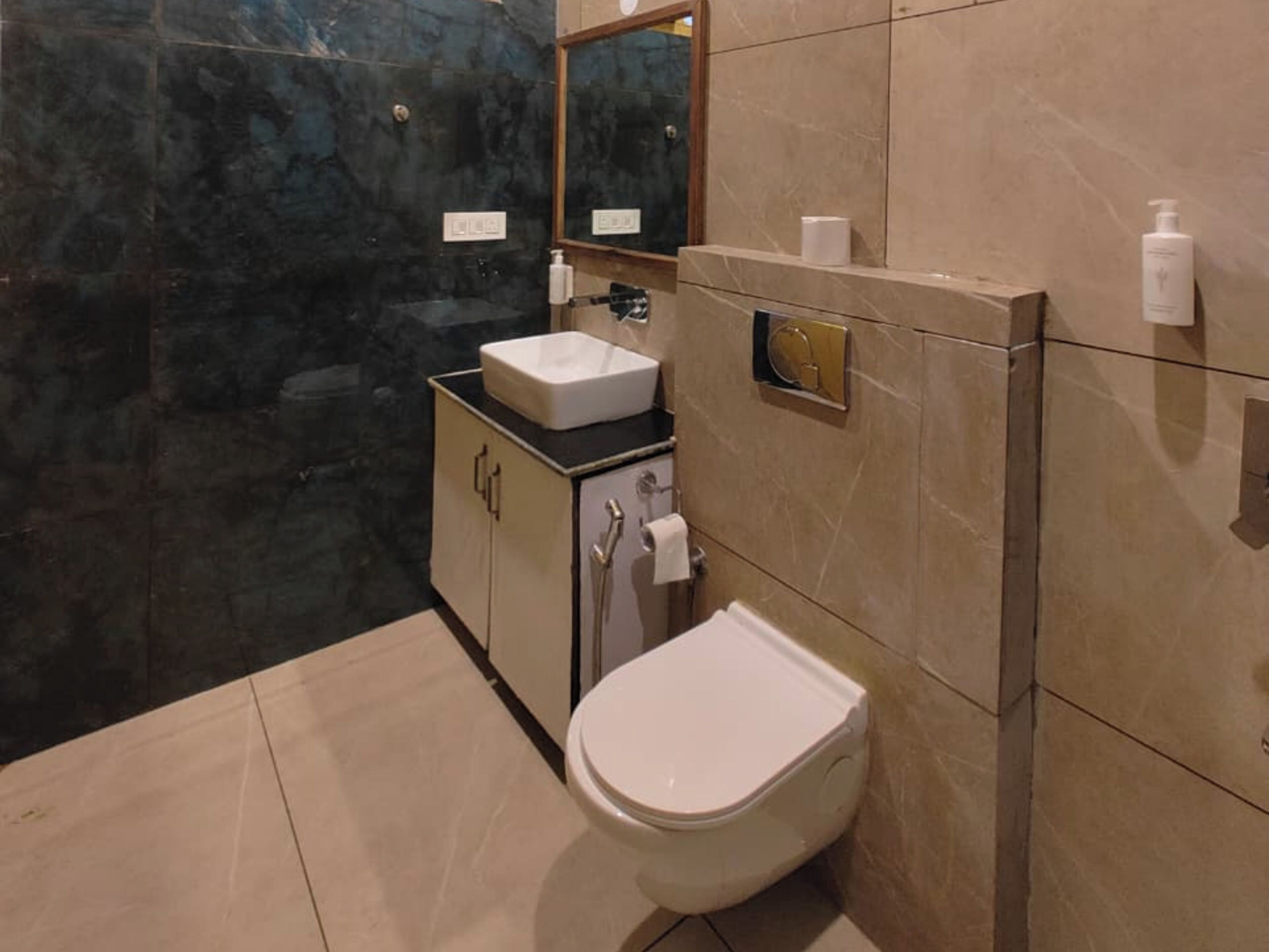 A bathroom with a toilet, sink, and mirror.