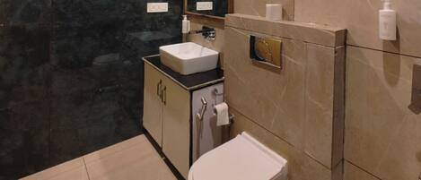 A bathroom with a toilet, sink, and mirror.