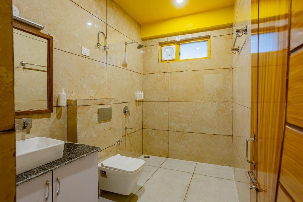 A bathroom with a sink, mirror, shower, and toilet.