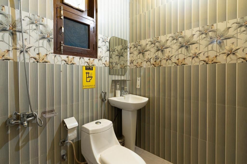 A bathroom with a toilet, sink, and shower.