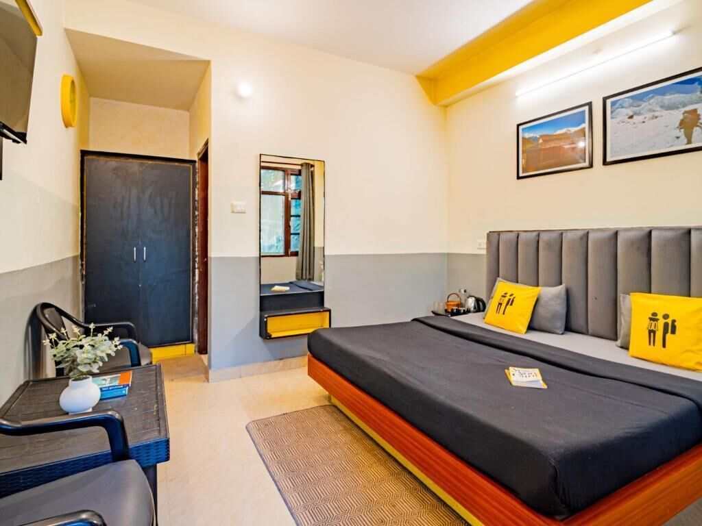 A bedroom with a bed, a desk, and a chair. There is a door and a window.