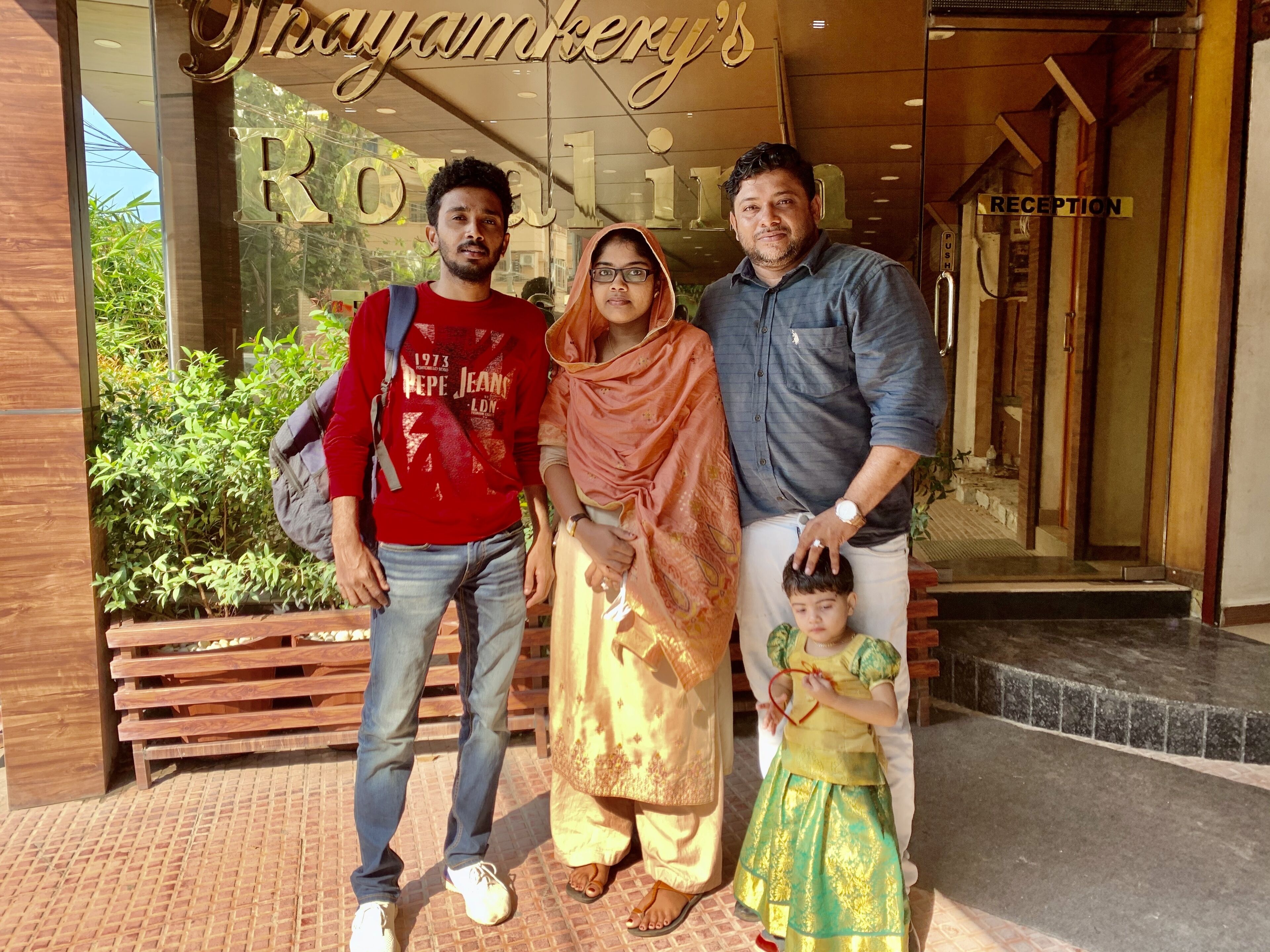 A family standing in front of a building with a reception area.