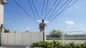 A building with a statue on a pedestal, surrounded by a fence and greenery. - Riposino (Marmirolo)