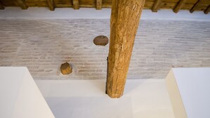 A room with a brick wall and wooden beams. - Riposino (Marmirolo)