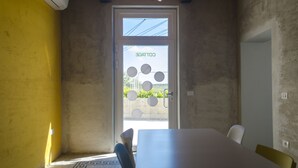A conference room with a white table, chairs, and a door with a circular window design. - Riposino (Marmirolo)