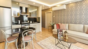 A modern kitchen with a dining area, a sofa, and a coffee table. - All Seasons Suites (Istanbul)