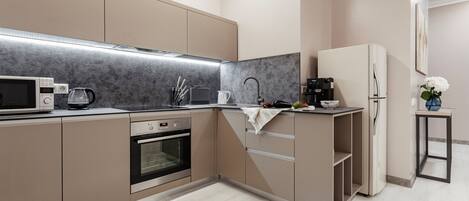 A modern kitchen with built-in appliances, a microwave, oven, and a coffee maker.