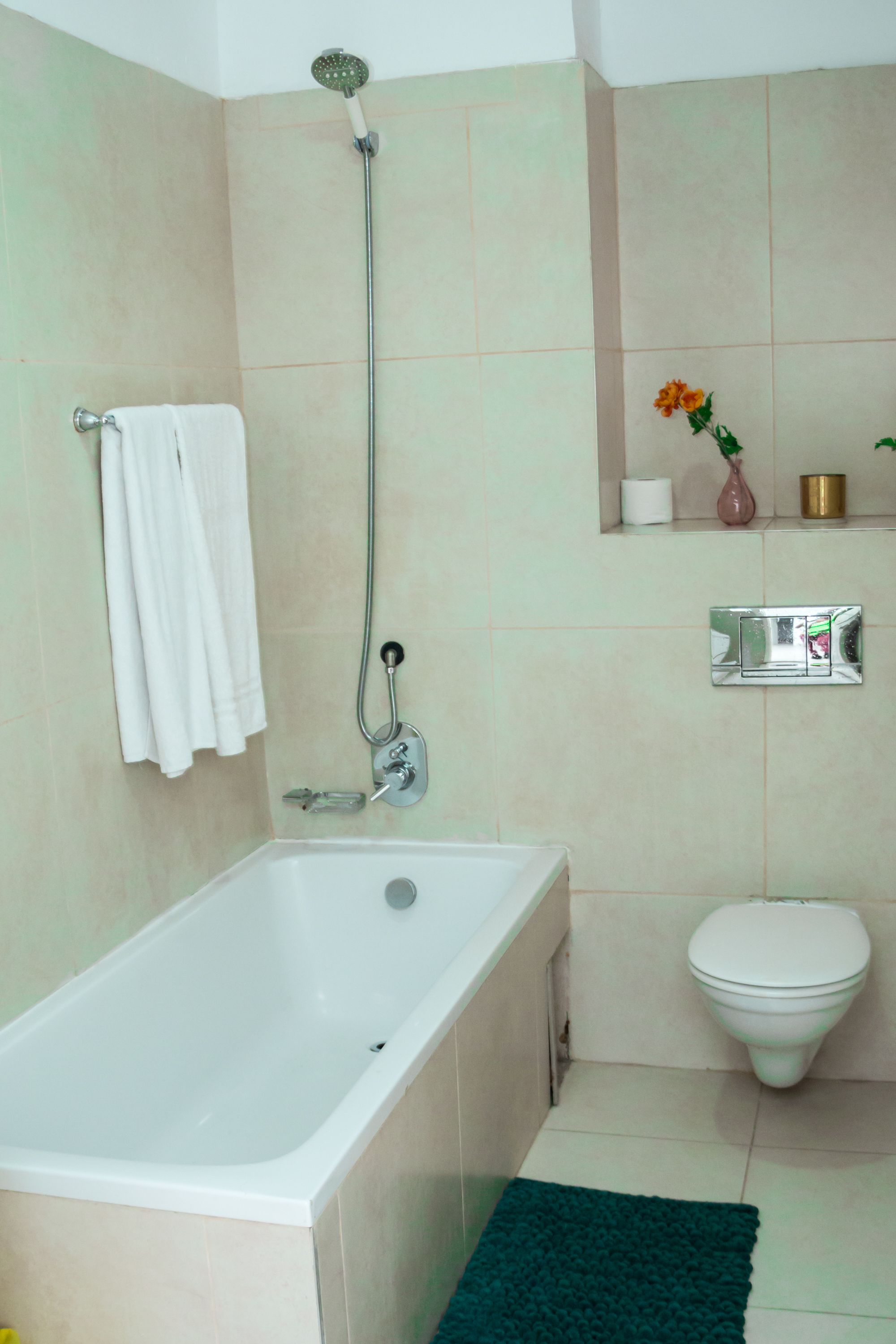 Een badkamer met een bad, toilet en douche.