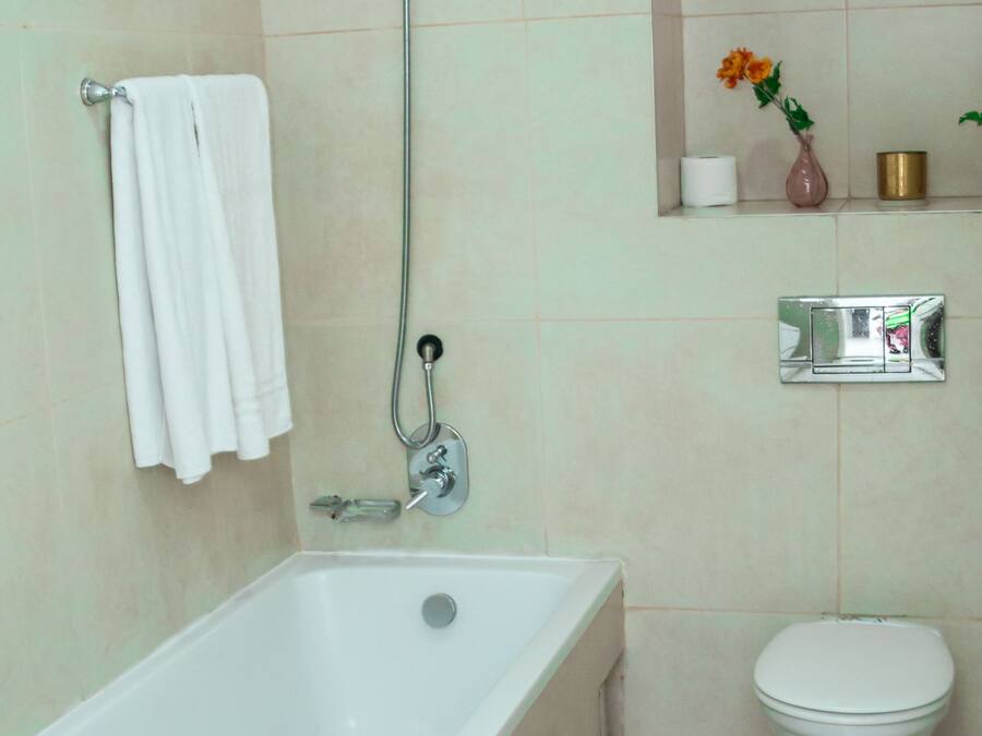 Een badkamer met een bad, toilet en douche.