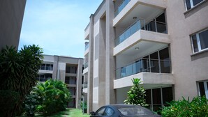 En moderne bygning med flere etager, altaner og store vinduer.