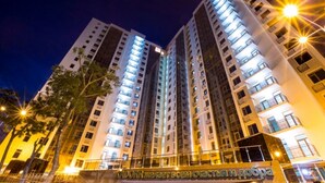 A high-rise building with multiple floors, illuminated windows, and a sign with Cyrillic text. - Arcadia Dream Apartments (Odesa)