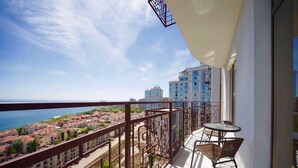 A balcony with a view of the sea and buildings. - Arcadia Dream Apartments (Odesa)