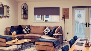 Una sala de estar moderna con un sofá seccional, una mesa de centro y un comedor con una mesa y sillas.