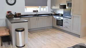 Una cocina moderna con una isla central, electrodomésticos de acero inoxidable y armarios de madera clara.