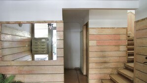 Ein Flur mit einer Holztreppe und einem Metallschrank.
