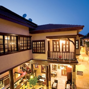 A traditional building with a courtyard, multiple dining areas, and a balcony with railings.