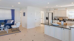 A modern kitchen with white cabinets, a black countertop, and a built-in oven. - Sunsets on the Sand (Indian Shores)