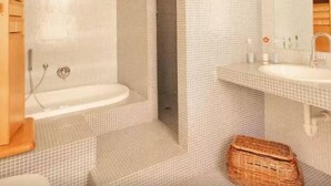 A bathroom with a bathtub, a sink, and a mirror. - I Fiori di Miranda (Casarza Ligure)