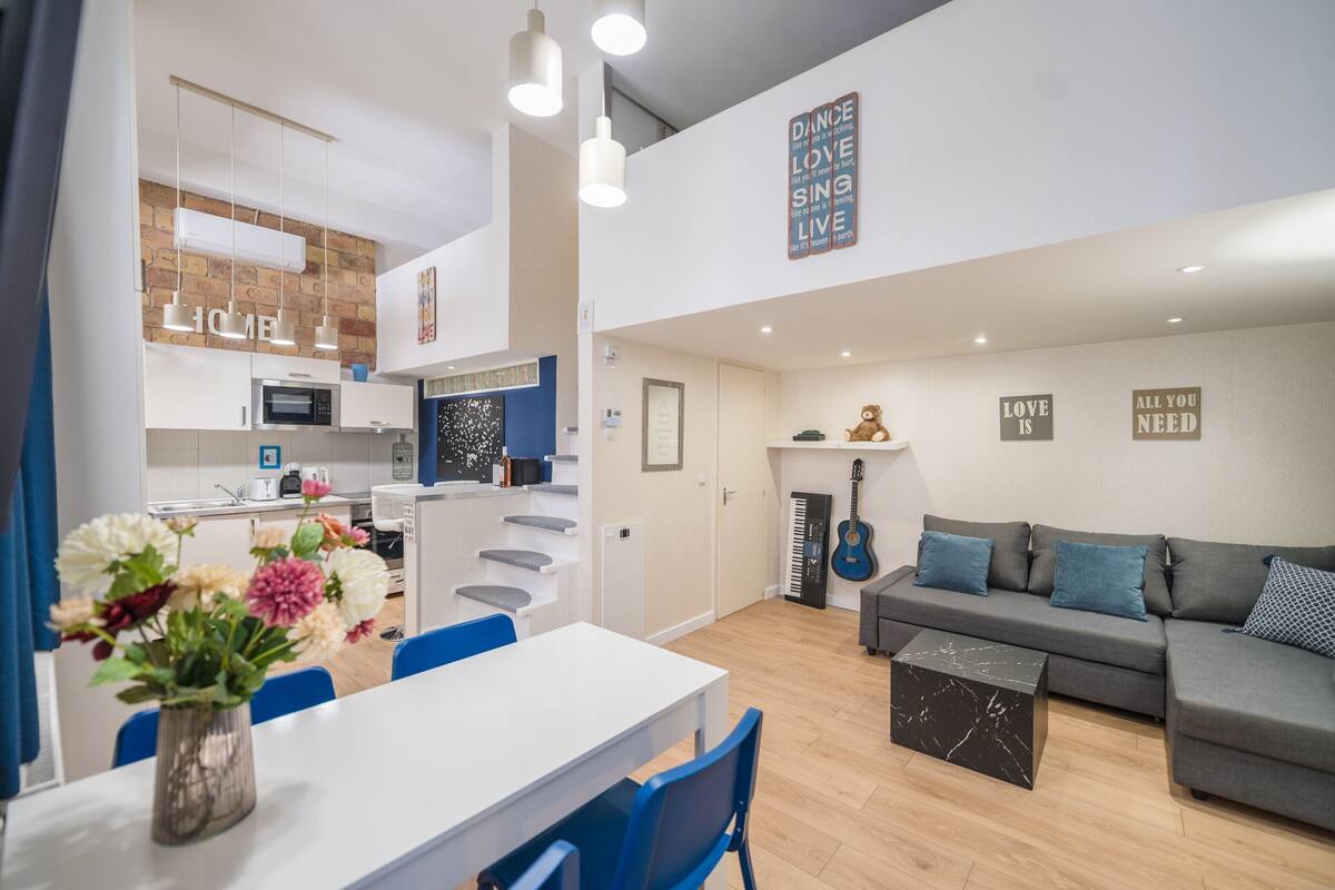 A modern apartment with a kitchen, dining area, and living room.