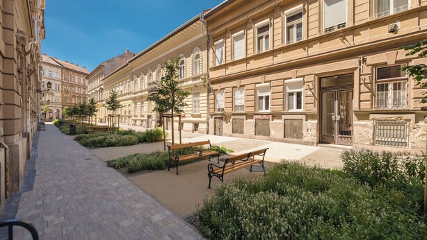 A courtyard with benches, a pathway, and buildings with large windows and balconies. - happy home Budapest BLUE (Budapest)