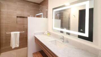 Un baño moderno con un espejo grande, un lavabo y un perchero para toallas.