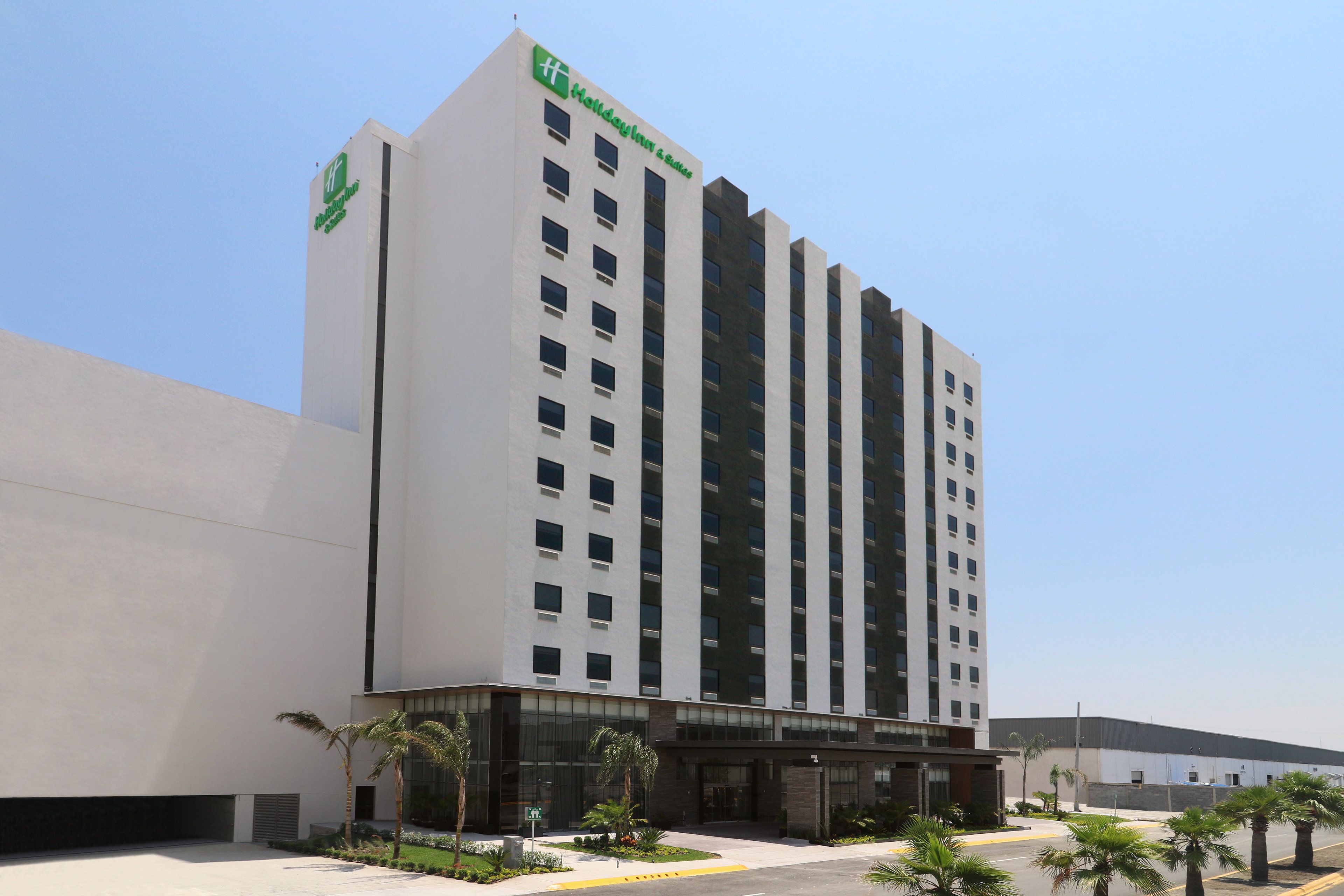Un hôtel moderne, facilement reconnaissable à son grand panneau « Holiday Inn Express », qui se distingue par son architecture imposante, avec de nombreux étages et une entrée centrale.