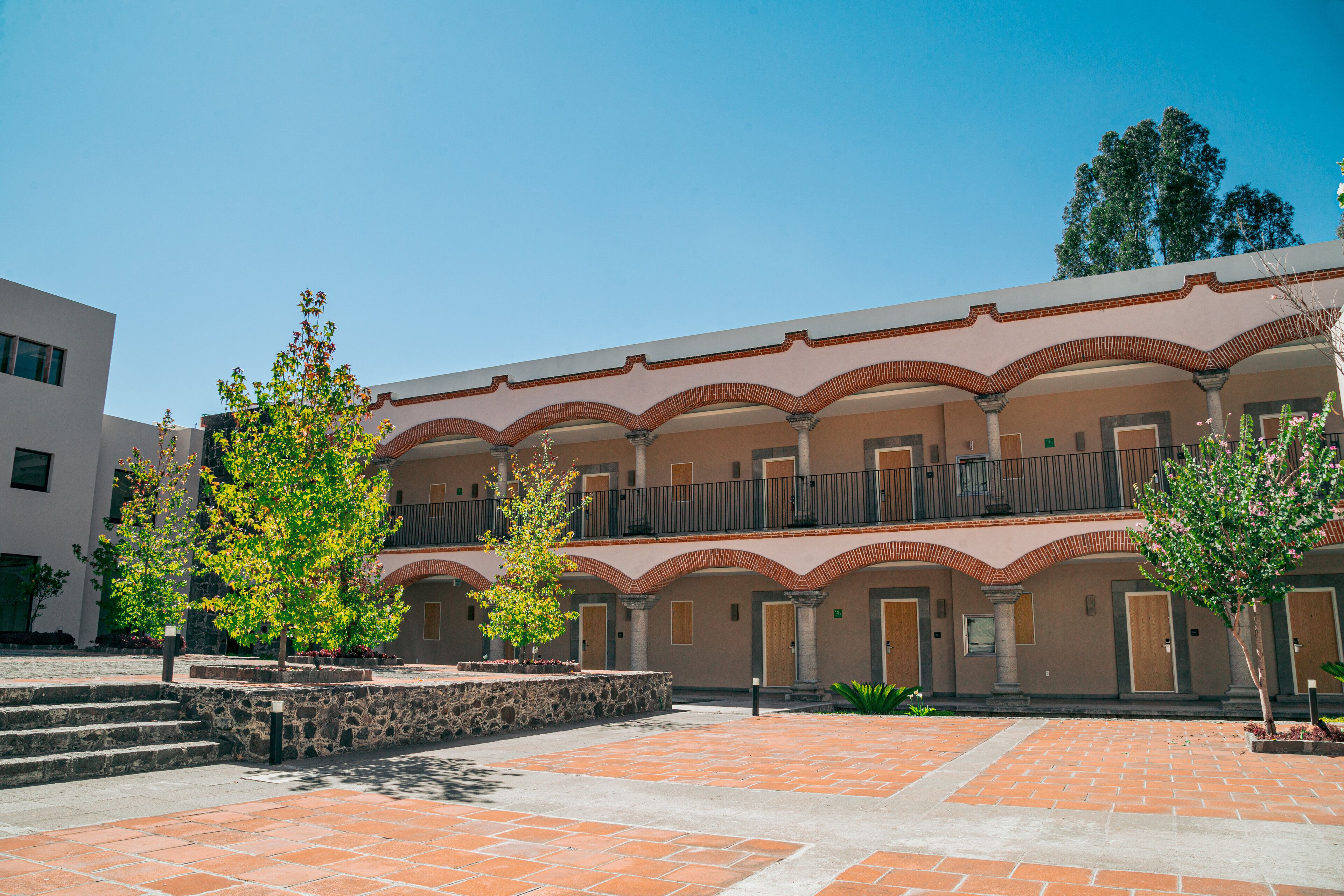 Un patio con un edificio que tiene techo de teja y varios balcones.