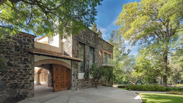 A stone building with a large wooden door and a covered entrance. - Holiday Inn Tlaxcala by IHG (Yauhquemehcan)