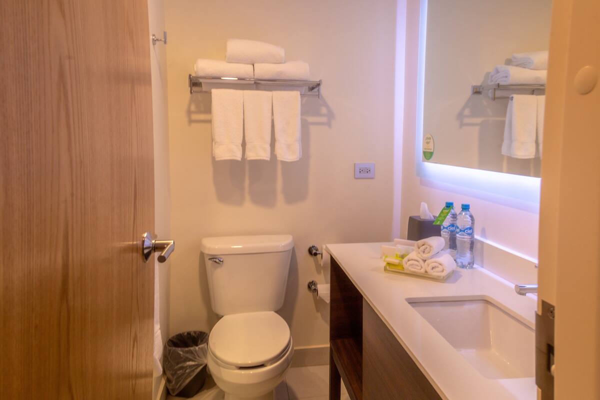 A bathroom with a toilet, a sink, and a towel rack.