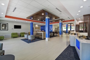 A spacious lobby with a reception desk, seating area, and a dining section. - Holiday Inn Express & Suites Houston NASA - Boardwalk Area by IHG (Seabrook)