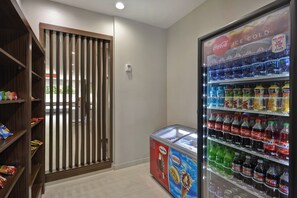 A vending machine with various beverages and a freezer with ice cream. - Holiday Inn Express & Suites Houston NASA - Boardwalk Area by IHG (Seabrook)