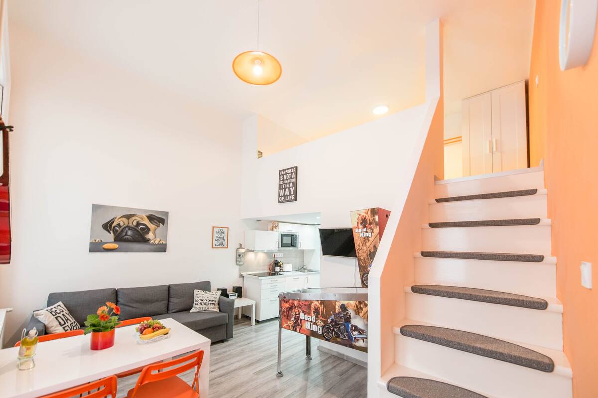 A modern apartment with a kitchen, dining area, and living room.