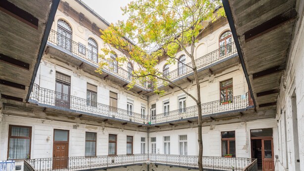 A multi-story building with balconies, arched windows, and a central courtyard. - happy home Budapest FOX (Budapest)