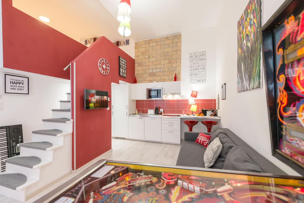 Un apartamento moderno con cocina, sala de estar y una escalera.