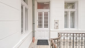 A white exterior with a double door, a small window, and a metal railing. - happy home Budapest FOX (Budapest)