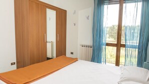 Une chambre à coucher avec un lit, une armoire en bois, une fenêtre avec des rideaux et des autocollants décoratifs représentant des papillons sur les murs.