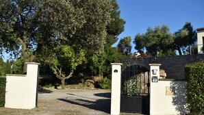 A gated entrance with a stone wall and a metal gate, surrounded by trees and a clear sky. - Olive Tree, Superb gîte, Heated Pool near Carcassonne, overlooking Canal du Midi (Marseillette)