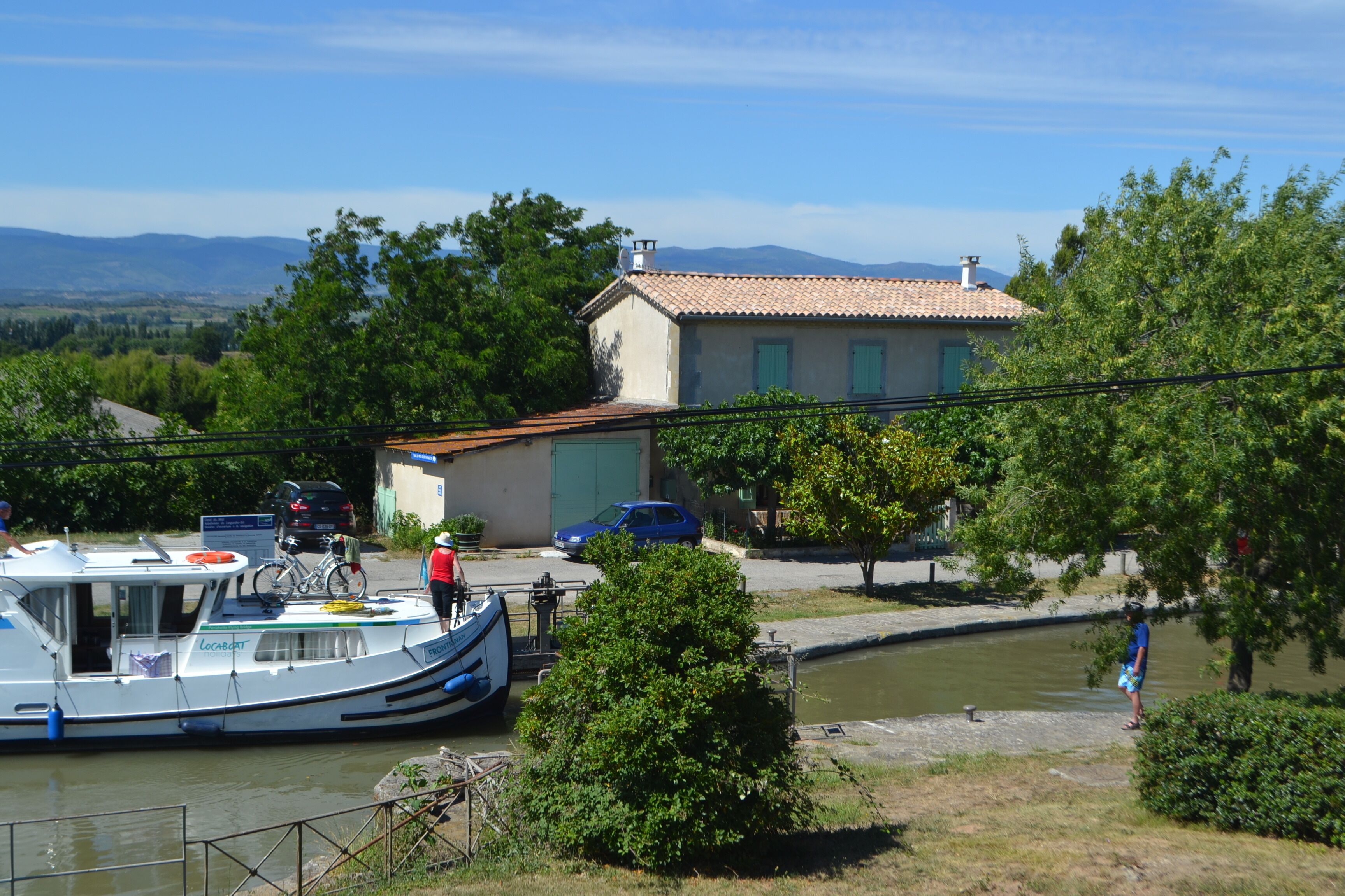 Un bateau était amarré près d’une maison d’où l’on pouvait admirer des montagnes en arrière-plan.