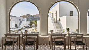 Un restaurant doté d’une terrasse, de murs blancs et offrant une vue sur un paysage montagneux.